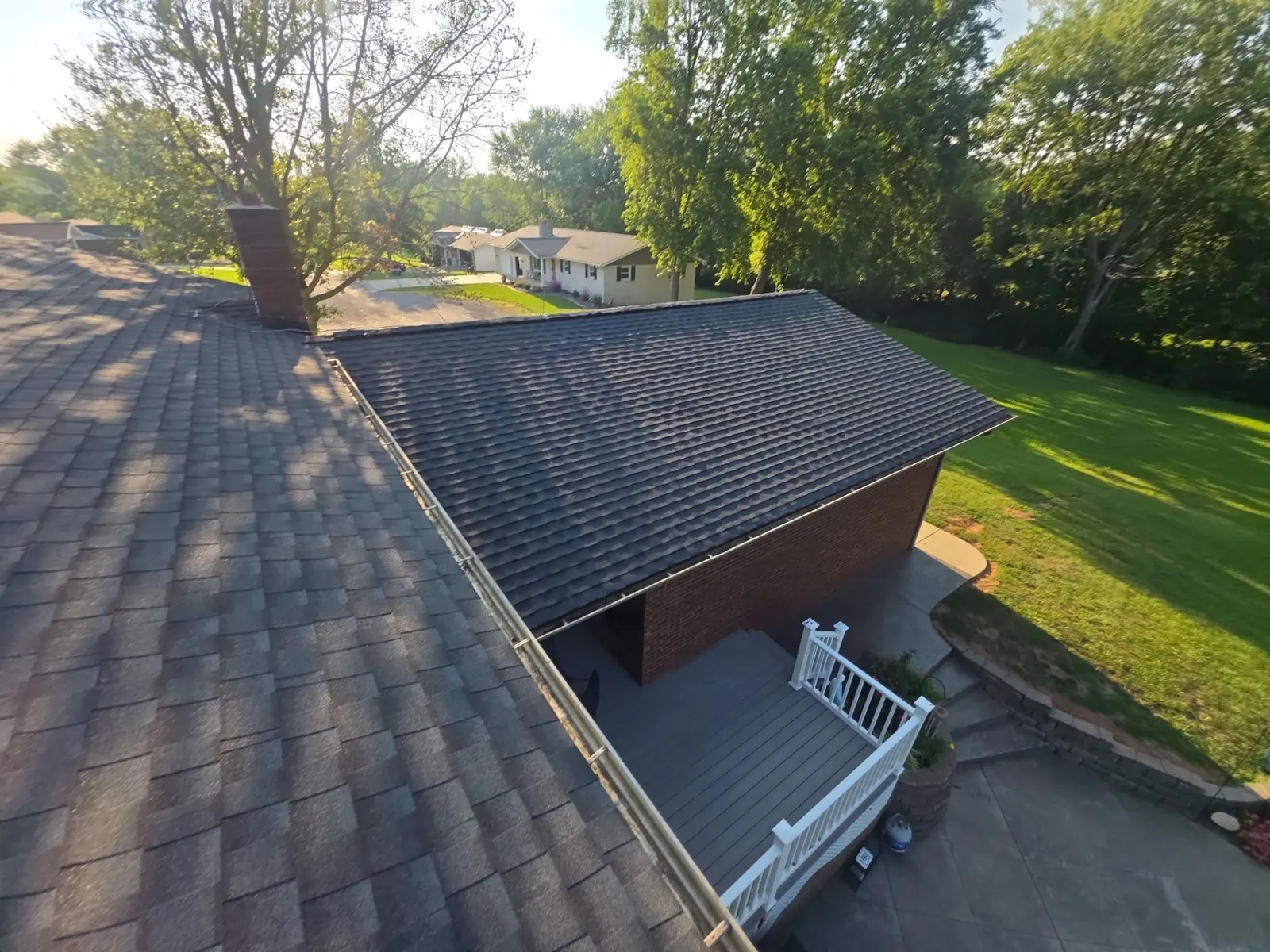 Aerial view of a new dark shingle roof and gutters on a home in Bartelso, IL
