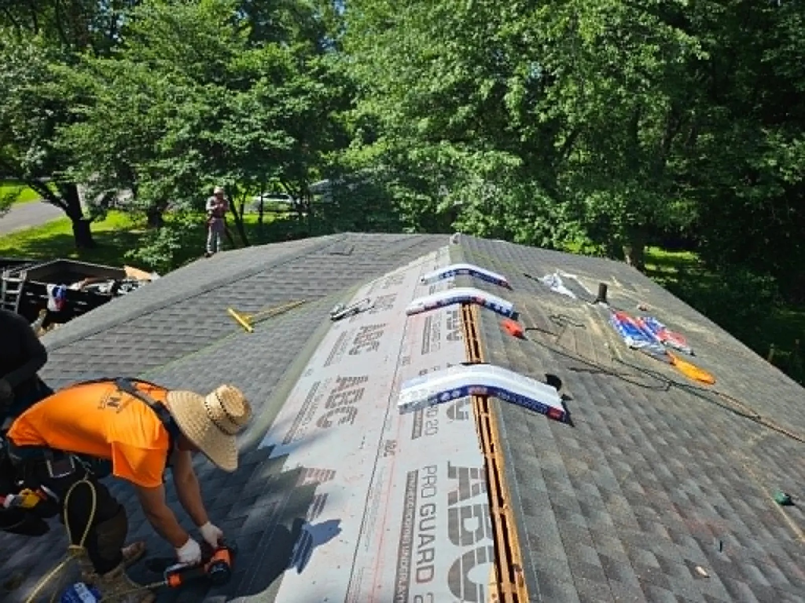 iRestore STL roofer installing ridge cap shingles over the ridge vent