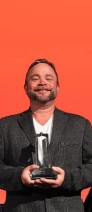 Kirk Kupsky, owner of iRestore STL, holding a GAF award