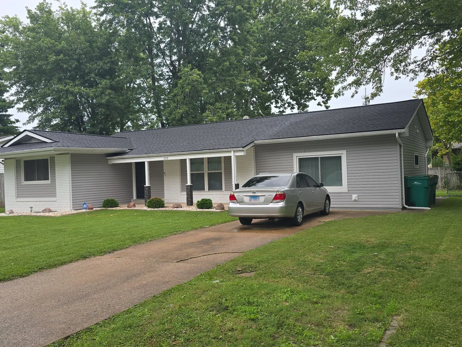 Completed roof replacement on a gray-sided ranch home in O'Fallon, IL