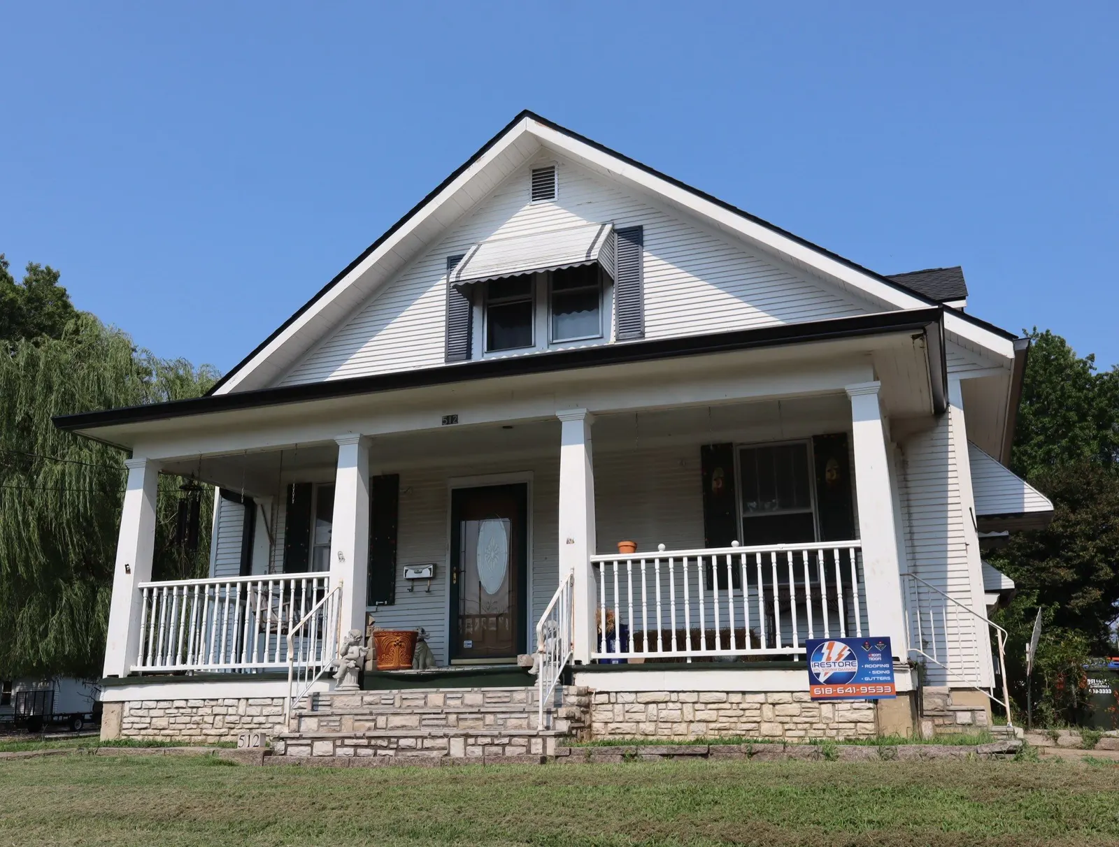 New roof and white gutters on a white bungalow with a covered front porch in Waterloo, IL